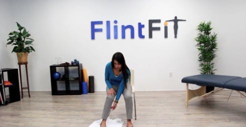 therapist with foot on towel for physical therapy exercise