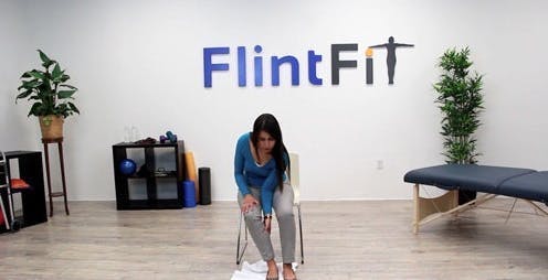 therapist sliding foot across floor with towel for assistance