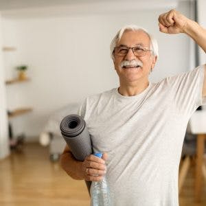 healthy mild stroke survivor holding a yoga mat after exercising at home