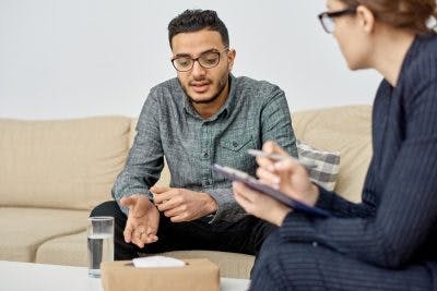 young man in psychologist office, learning how to overcome tics after head trauma