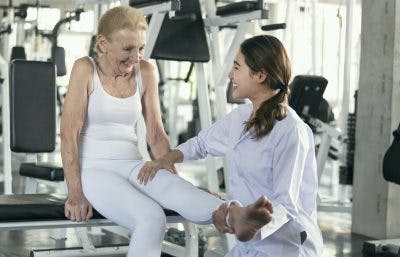 therapist moving spinal cord injury patient's legs to help her manage her cold feet