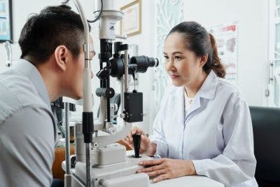 ophthalmologist examining patient's eye to find a treatment for his nystagmus after head injury