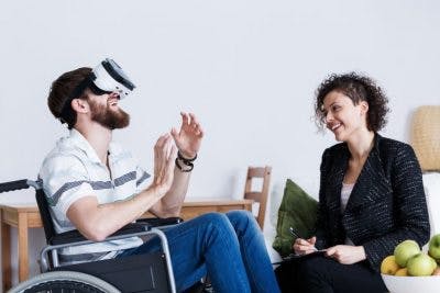 man in wheelchair using virtual reality headset 