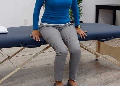 therapist sitting on edge of therapy table