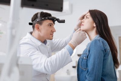 doctor examining patient's nose to see what is causing her anosmia after head trauma