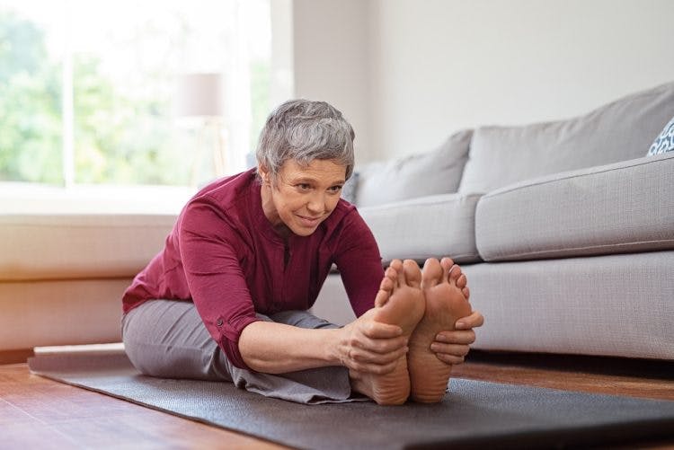 Woman doing floor exercises and stretching her feet because she has foot drop after TBI