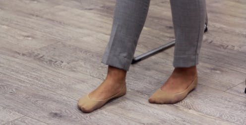 Physiotherapeut mit flachen Füßen auf dem Boden und einem Fuß nach vorne