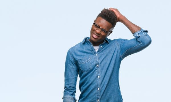 Young african american man over isolated background scratching head and looking confused because he has different types of agnosia after brain injury