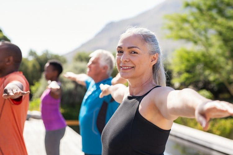 woman in outdoor fitness class doing balance exercises for stroke patients