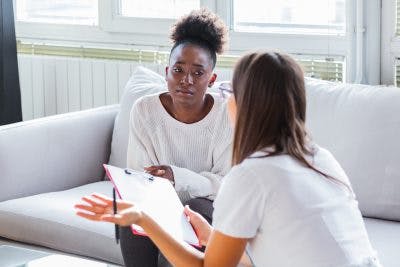 young woman talking to therapist about psychogenic stuttering
