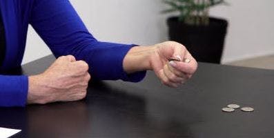Therapeut kneift ein Viertel zwischen Daumen und Zeigefinger