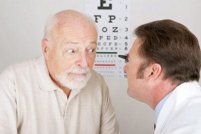 doctor examining elderly patients vision to see if he suffered a head injury