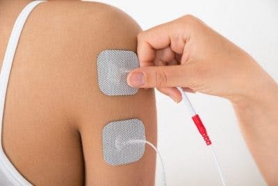 Therapeut, der eine elektrische Stimulation auf einen Patienten mit massivem Schlaganfall anwendet