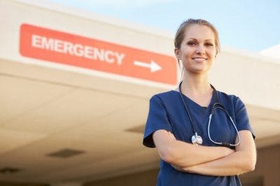 doctor standing outside emergency room looking at camera confidently