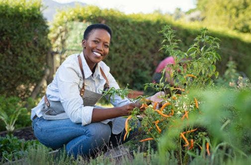 stroke patient posing with gardening tools in backyard