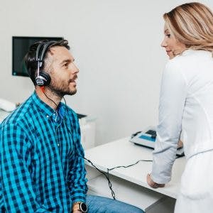 audiologist performing a hearing test on survivor in order to diagnose tinnitus after head injury