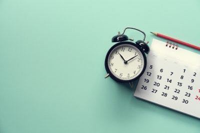 clock on mint green background next to calendar to represent the time you need to achieve long-term goals for TBI patients