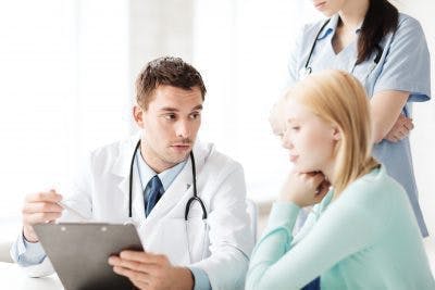 Arzt bespricht Taubheitsbehandlung mit Schlaganfallpatient mit Krankenschwester, die im Hintergrund steht