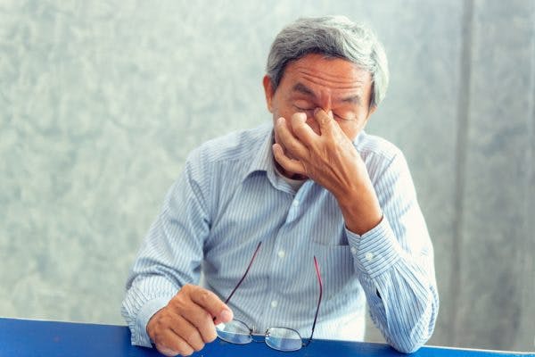Stressed senior man rubbing bridge of nose