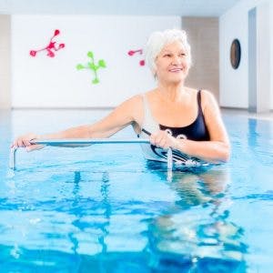 survivor in pool waiting to train with therapist after learning of the benefits of aquatic therapy for spinal cord injury