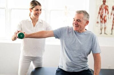 therapist helping stroke patient exercise arm