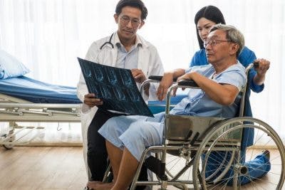 doctor explaining causes of hemiplegia vs hemiparesis after stroke to stroke patient in hospital room