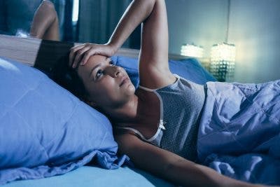 woman lying in bed awake with anxiety