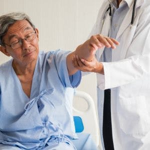 Doctor testing stroke patient's arm for learned nonuse