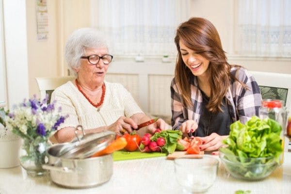 brain injury patient preparing healthy foods in kitchen with caregiver