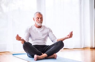 man with spinal cord injury practicing yoga on mat