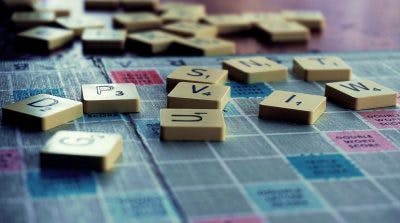 scrabble board with various scrabble tiles scattered on it