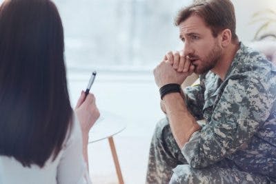 soldier listening to psychotherapist talk to him about traumatic brain injury and PTSD