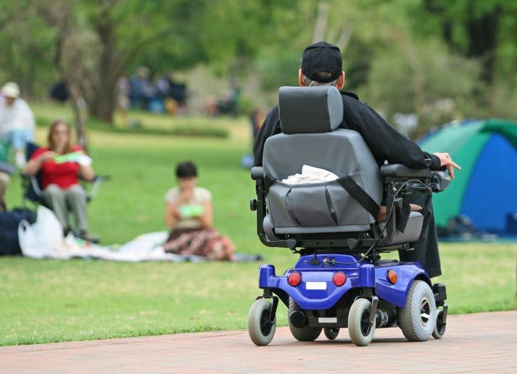 spinal cord injury patient using adaptive equipment like power wheelchairs to improve mobility