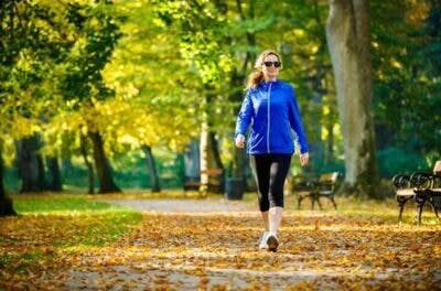 woman walking through park as an alternative to caffeine after brain injury