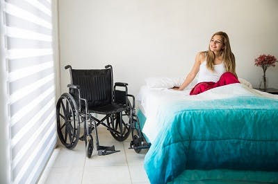 woman with spinal cord injury practicing bed mobility exercises
