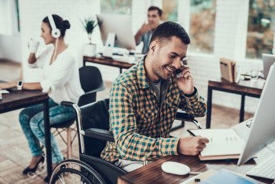 man living with paraplegia and working