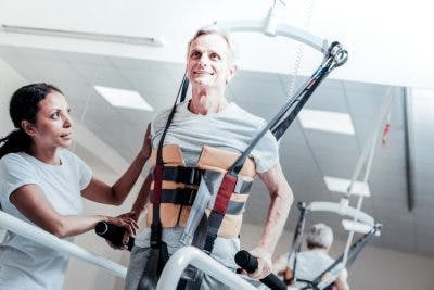 SCI patient practicing leg exercises on weight-bearing treadmill