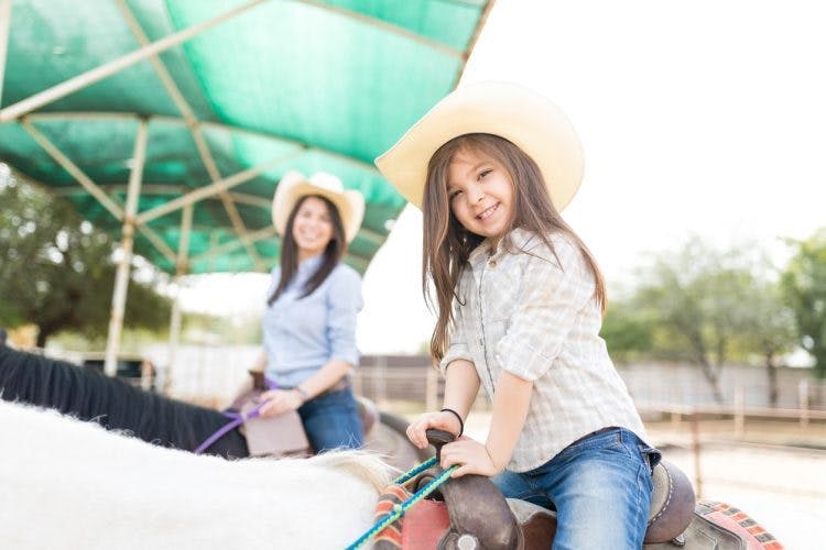 little girl with cerebral palsy participating in hippotherapy to improve trunk stability