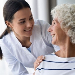 nurse helping elderly patient with global aphasia