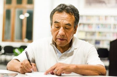 senior man drawing on paper as part of his aphasia therapy