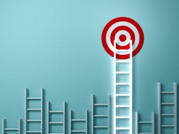 a ladder leaning up against a wall with the top reaching a target on the wall to illustrate accomplishing goals after stroke
