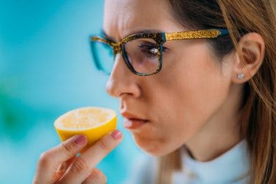 woman sniffing orange slice