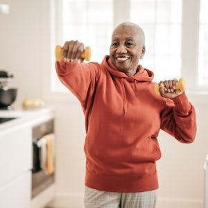 Stroke patient with dumbbells exercising at home with simple equipment