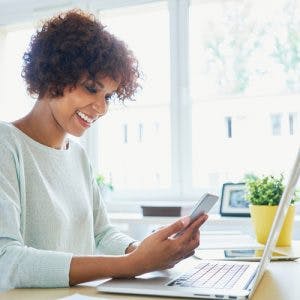 woman smiling while looking at computer researching disability benefits after stroke