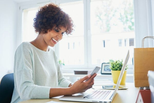 woman smiling while looking at computer researching disability benefits after stroke