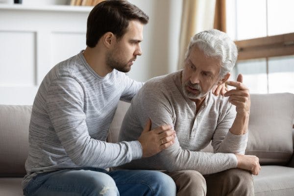 adult son trying to help elderly father cope with anger after stroke