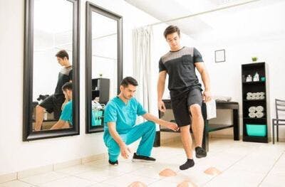 Un physiothérapeute aide un patient à effectuer des exercices de rééducation après un AVC.