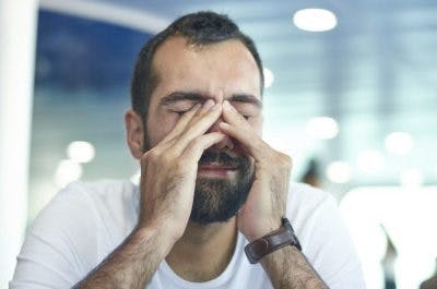 man rubbing his eyes because he is fatigued