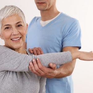physiotherapist helping a stroke survivor with arm mobility after her symptoms started getting worse
