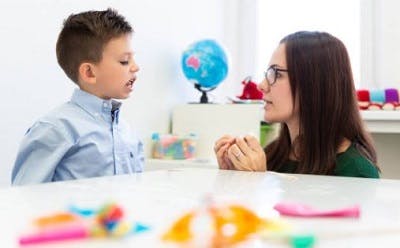 child with cp working with a speech language pathologist to strengthen oral muscles